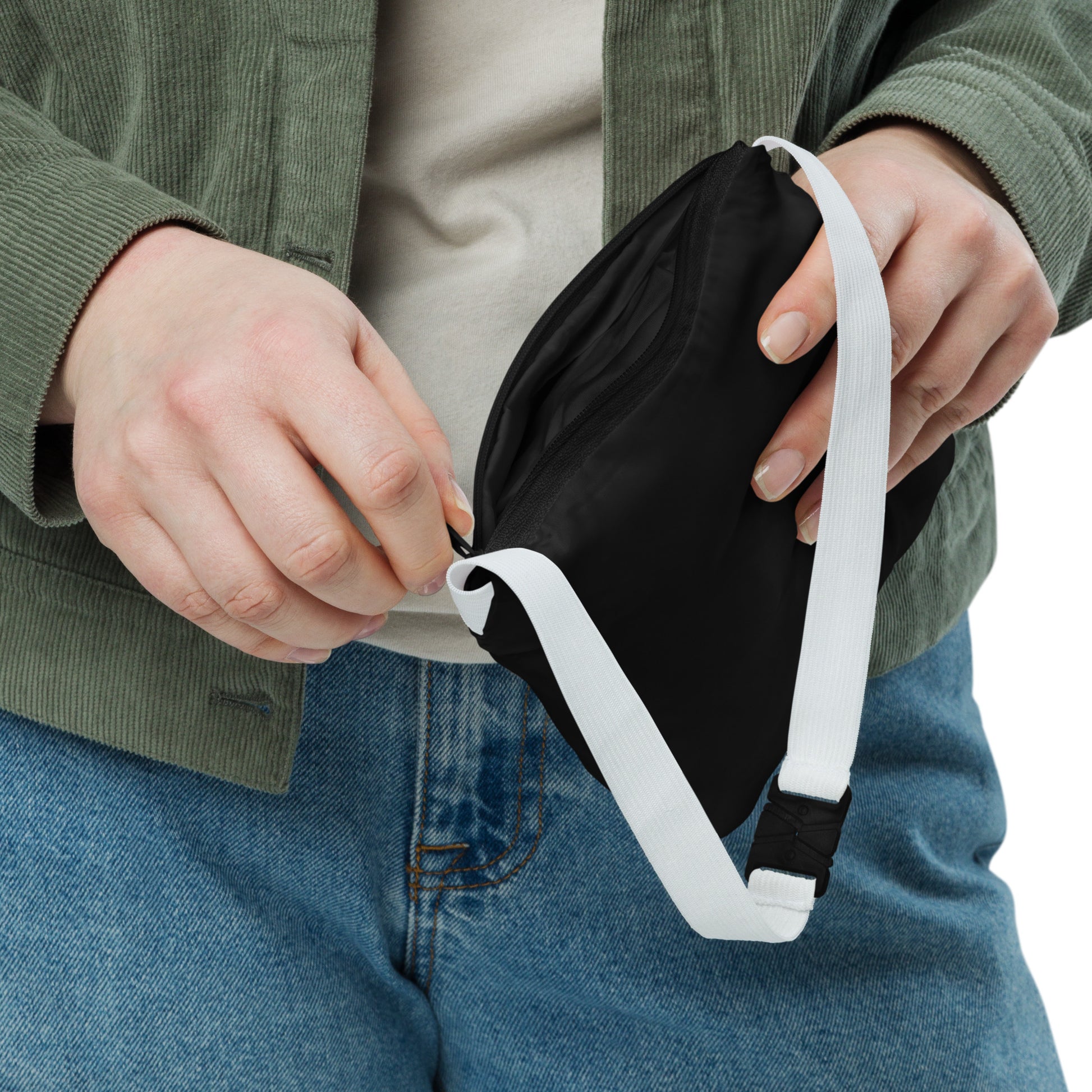 Person holding a black waist bag with a white strap